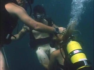 女孩在潛水裝備做兩個潛水員的口交
